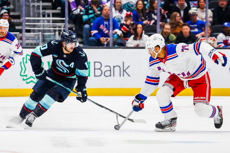 Nov 17, 2024; Seattle, Washington, USA; New York Rangers defenseman K'Andre Miller (79) beats Seattle Kraken center Matty Beniers (10) to a loose puck during the third period at Climate Pledge Arena. Mandatory Credit: Joe Nicholson-Imagn Images