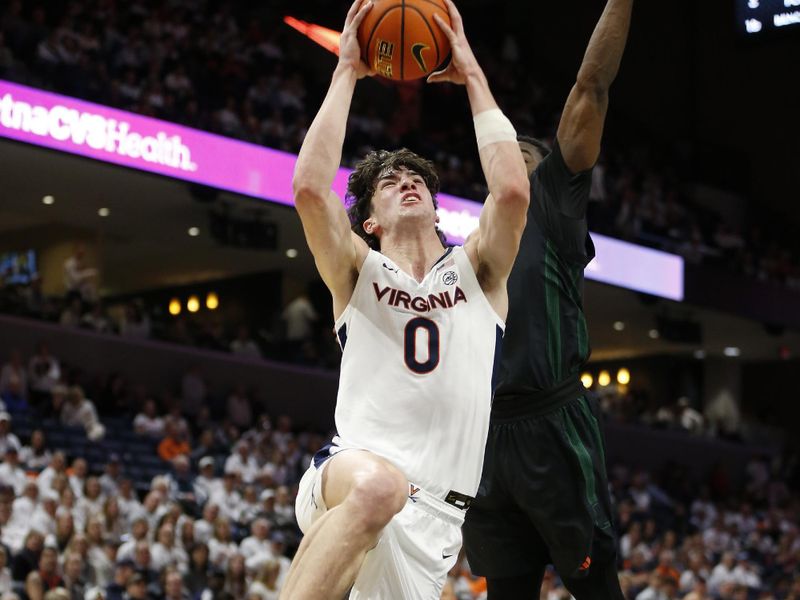 Feb 5, 2024; Charlottesville, Virginia, USA; Virginia Cavaliers forward Blake Buchanan (0) shoots the ball past Miami (Fl) Hurricanes guard Bensley Joseph (4) during the second half at John Paul Jones Arena. Mandatory Credit: Amber Searls-USA TODAY Sports