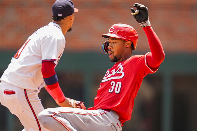 Jul 24, 2024; Cumberland, Georgia, USA; Cincinnati Reds center fielder Will Benson (30) slides into second base past Atlanta Braves shortstop Orlando Arcia (11) after hitting a double during the eighth inning at Truist Park. Mandatory Credit: Dale Zanine-USA TODAY Sports