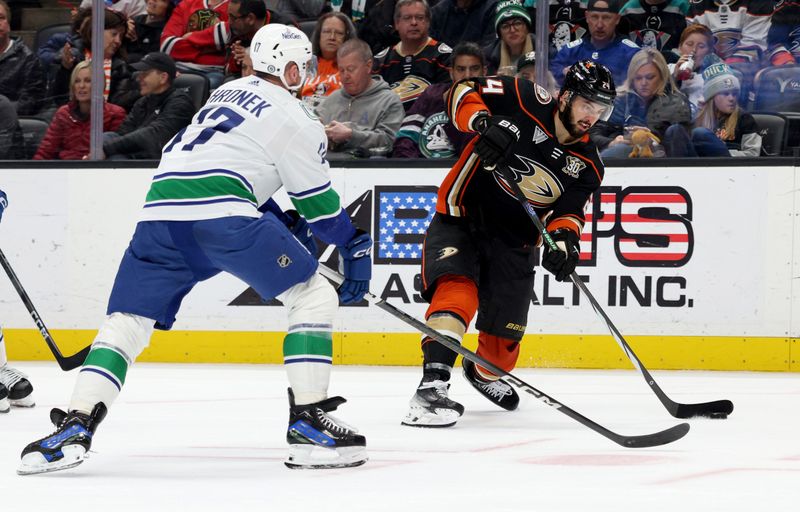 Mar 3, 2024; Anaheim, California, USA; Anaheim Ducks center Bo Groulx (24) shoots against Vancouver Canucks defenseman Filip Hronek (17) during the second period at Honda Center. Mandatory Credit: Jason Parkhurst-USA TODAY Sports