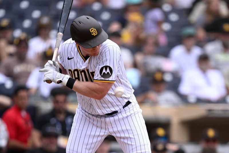 Aug 19, 2023; San Diego, California, USA; San Diego Padres first baseman Garrett Cooper (24) is hit by a pitch during the ninth inning against the Arizona Diamondbacks at Petco Park. Mandatory Credit: Orlando Ramirez-USA TODAY Sports