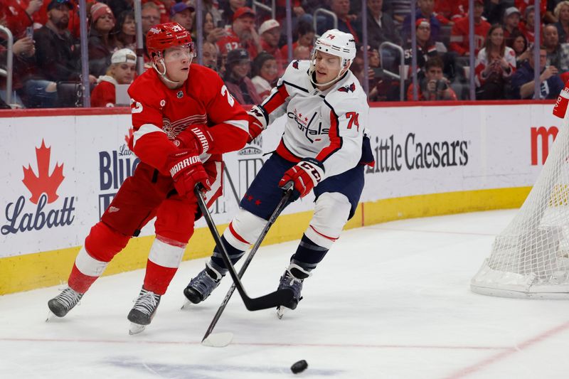 Apr 9, 2024; Detroit, Michigan, USA;  Detroit Red Wings left wing Lucas Raymond (23) skates with the puck chased by Washington Capitals defenseman John Carlson (74) in the second period at Little Caesars Arena. Mandatory Credit: Rick Osentoski-USA TODAY Sports