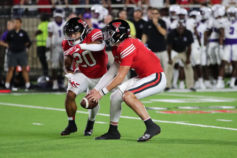 Sep 16, 2023; Lubbock, Texas, USA;  Texas Tech Red Raiders quarterback Behren Morton (2) takes a low snap in front of running back Nehemiah Martinez I (20) in the second half at Jones AT&T Stadium and Cody Campbell Field. Mandatory Credit: Michael C. Johnson-USA TODAY Sports