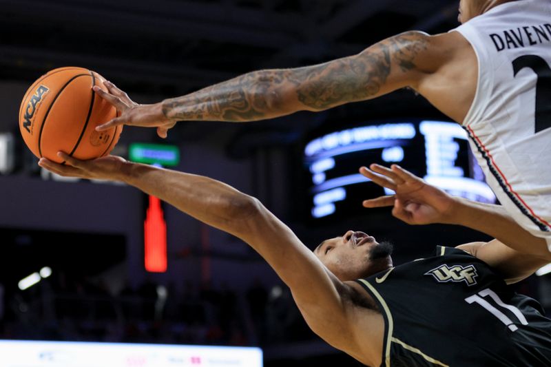 Feb 4, 2023; Cincinnati, Ohio, USA;  UCF Knights guard Tyem Freeman (11) is blocked by Cincinnati Bearcats guard Jeremiah Davenport (24) as he drives to the basket in the second half at Fifth Third Arena. Mandatory Credit: Aaron Doster-USA TODAY Sports