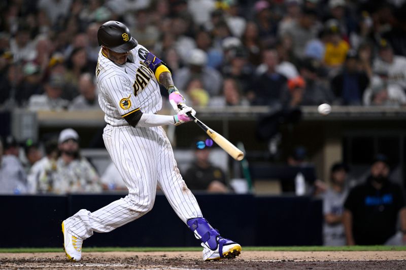 Aug 21, 2023; San Diego, California, USA; San Diego Padres third baseman Manny Machado (13) hits a home run against the Miami Marlins during the fifth inning at Petco Park. Mandatory Credit: Orlando Ramirez-USA TODAY Sports