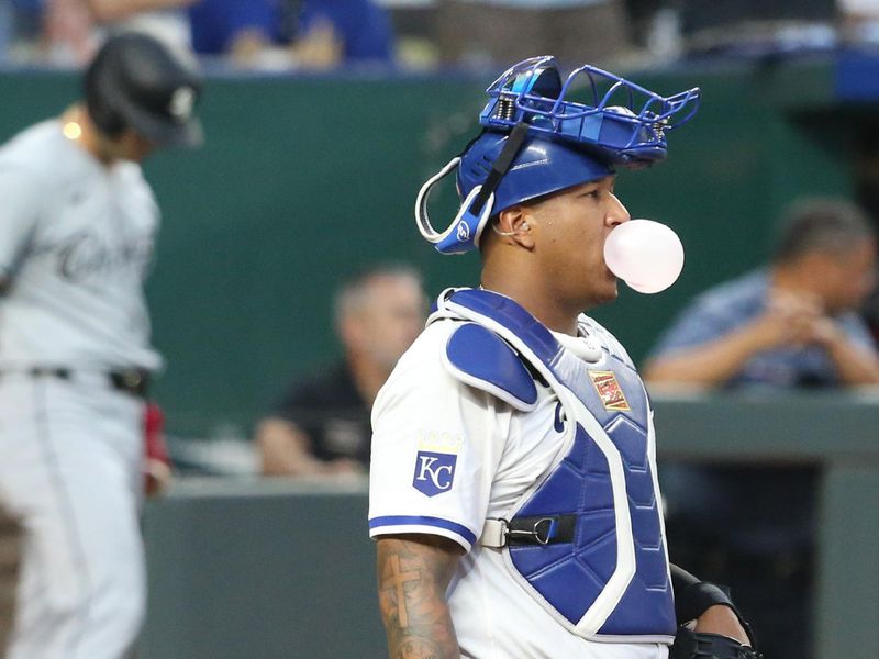 Jul 20, 2024; Kansas City, Missouri, USA; Kansas City Royals catcher Salvador Perez (13) blows a bubble during a break in action against the Chicago White Sox in the top of the ninth inning at Kauffman Stadium. Mandatory Credit: Scott Sewell-USA TODAY Sports