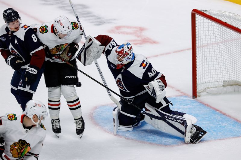 Oct 28, 2024; Denver, Colorado, USA; Colorado Avalanche goaltender Alexandar Georgiev (40) makes a save as Chicago Blackhawks center Ryan Donato (8) and defenseman Cale Makar (8) battle for position in the first period at Ball Arena. Mandatory Credit: Isaiah J. Downing-Imagn Images