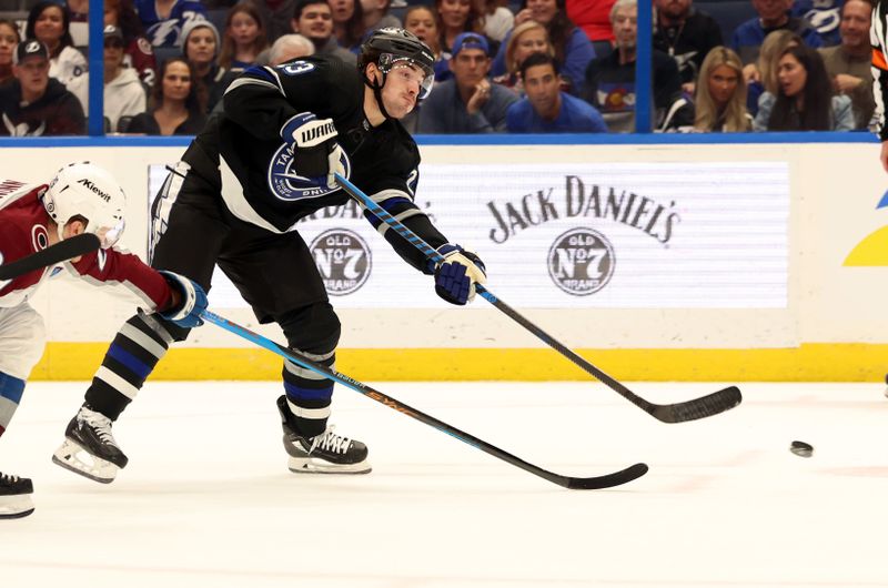 Feb 15, 2024; Tampa, Florida, USA; Tampa Bay Lightning center Michael Eyssimont (23) passes the puck as Colorado Avalanche center Nathan MacKinnon (29) defends during the first period at Amalie Arena. Mandatory Credit: Kim Klement Neitzel-USA TODAY Sports