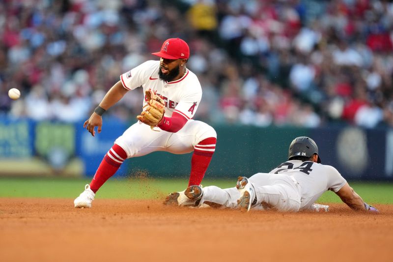May 28, 2025; Anaheim, California, USA; New York Yankees left fielder Jasson Dominguez (24) slides into second base to beat a throw to Los Angeles Angels second baseman Luis Rengifo (2) for a stolen base in the third inning at Angel Stadium. Mandatory Credit: Kirby Lee-Imagn Images
