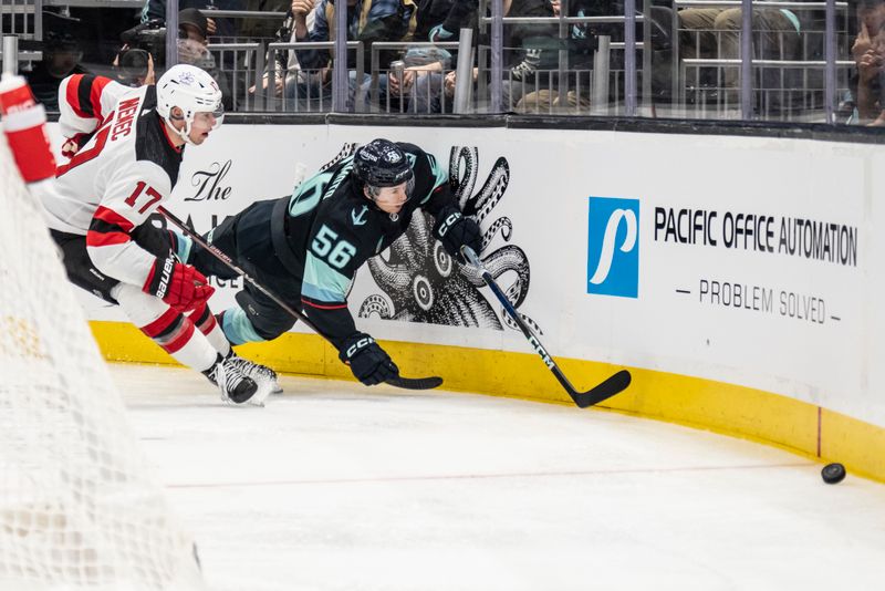 Dec 7, 2023; Seattle, Washington, USA; New Jersey Devils defenseman Simon Nemec (17) and Seattle Kraken forward Kailer Yamamoto (56) battle for trhe puck during the second period at Climate Pledge Arena. Mandatory Credit: Stephen Brashear-USA TODAY Sports