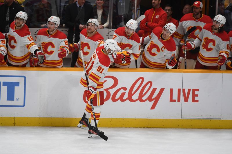 Jan 4, 2024; Nashville, Tennessee, USA; Calgary Flames center Nazem Kadri (91) is congratulated by teammates after a goal during the first period against the Nashville Predators at Bridgestone Arena. Mandatory Credit: Christopher Hanewinckel-USA TODAY Sports