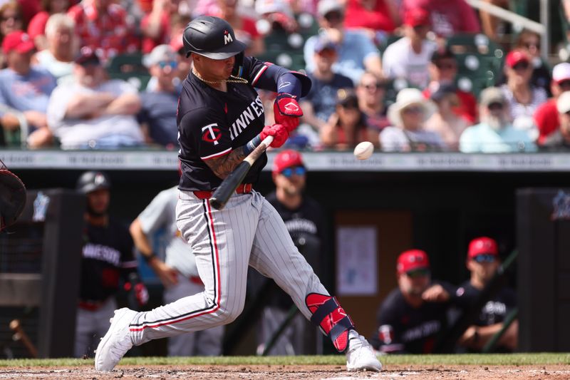 Mar 5, 2024; Jupiter, Florida, USA; Minnesota Twins designated hitter Jose Miranda (64) hits an rbi single against the St. Louis Cardinals during the fourth inning at Roger Dean Chevrolet Stadium. Mandatory Credit: Sam Navarro-USA TODAY Sports