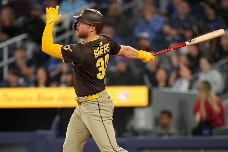 May 22, 2025; Toronto, Ontario, CAN; San Diego Padres first baseman Gavin Sheets (30) hits his second two run home run of the game against the Toronto Blue Jays during the ninth inning at Rogers Centre. Mandatory Credit: John E. Sokolowski-Imagn Images