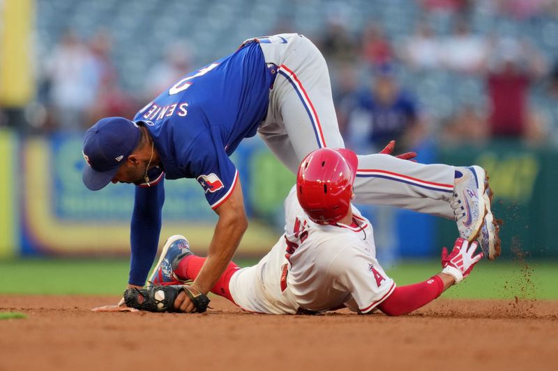 Jul 10, 2024; Anaheim, California, USA; Los Angeles Angels shortstop Zach Neto (9) is tagged out by Texas Rangers second baseman Marcus Semien (2) in the third inning  at Angel Stadium. Mandatory Credit: Kirby Lee-USA TODAY Sports
