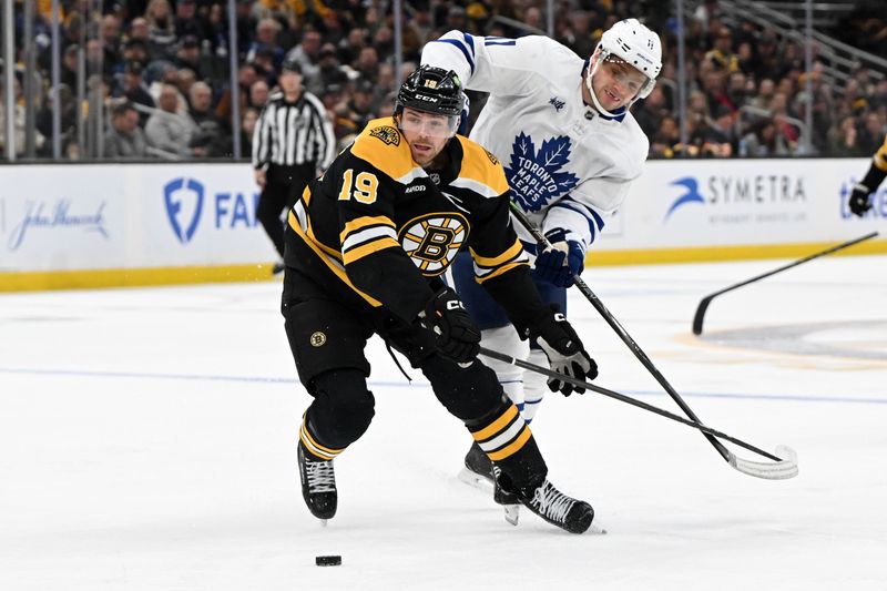 Feb 25, 2025; Boston, Massachusetts, USA; Boston Bruins center John Beecher (19) and Toronto Maple Leafs center Max Domi (11) battle for the puck during the second period at the TD Garden. Mandatory Credit: Brian Fluharty-Imagn Images