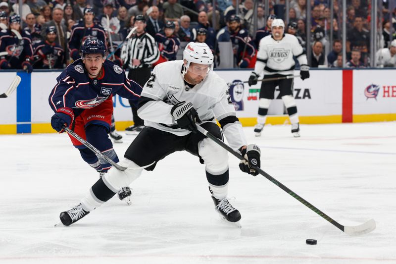 Mar 9, 2026; Columbus, Ohio, USA; Los Angeles Kings defenseman Brian Dumoulin (2) carries the puck as Columbus Blue Jackets left wing Mason Marchment (17) defends during the first period at Nationwide Arena. Mandatory Credit: Russell LaBounty-Imagn Images