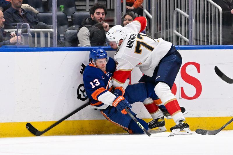 Oct 26, 2024; Elmont, New York, USA;  Florida Panthers defenseman Niko Mikkola (77) check New York Islanders center Mathew Barzal (13) into the boards during the third period at UBS Arena. Mandatory Credit: Dennis Schneidler-Imagn Images