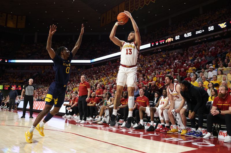 Feb 27, 2023; Ames, Iowa, USA; Iowa State Cyclones guard Jaren Holmes (13) shoots over West Virginia Mountaineers guard Kedrian Johnson (0) during the second half at James H. Hilton Coliseum. Mandatory Credit: Reese Strickland-USA TODAY Sports