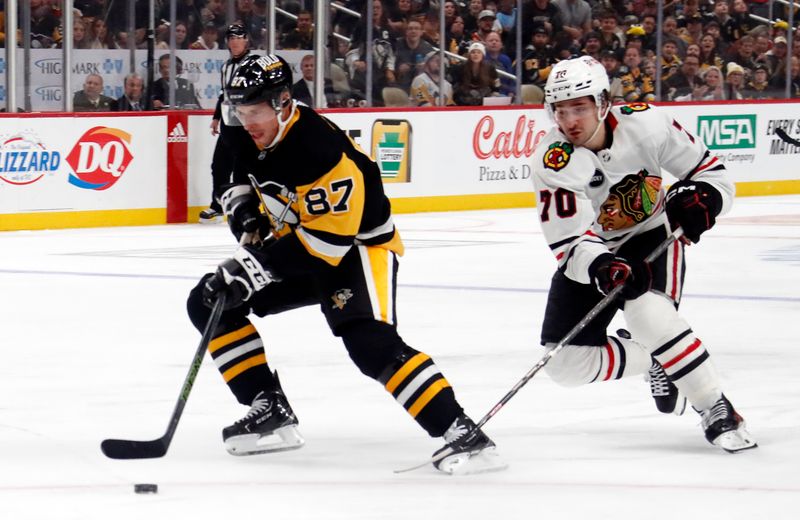 Oct 10, 2023; Pittsburgh, Pennsylvania, USA; Pittsburgh Penguins center Sidney Crosby (87) moves in on goal ahead of Chicago Blackhawks center Cole Guttman (70) during the first period at the PPG Paints Arena. Mandatory Credit: Charles LeClaire-USA TODAY Sports