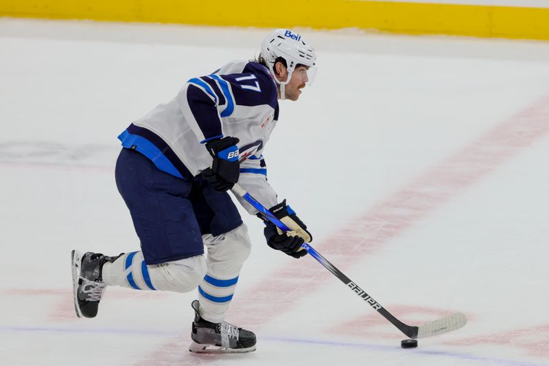 Nov 24, 2023; Sunrise, Florida, USA; Winnipeg Jets center Adam Lowry (17) moves the puck against the Florida Panthers during the third period at Amerant Bank Arena. Mandatory Credit: Sam Navarro-USA TODAY Sports