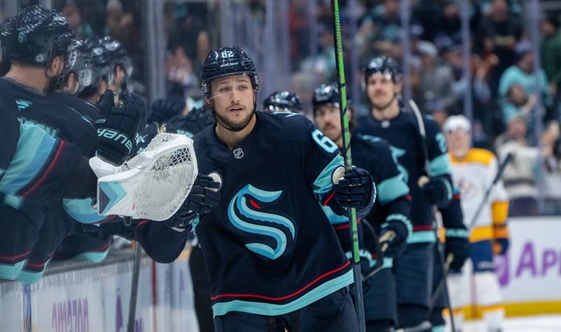 Nov 20, 2024; Seattle, Washington, USA;  Seattle Kraken defenseman Brandon Montour (62) is congratulated by teammates on bench after scoring a goal during the third period against the Nashville Predators at Climate Pledge Arena. Mandatory Credit: Stephen Brashear-Imagn Images