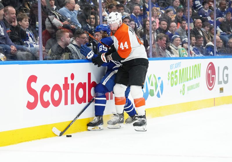 Feb 15, 2024; Toronto, Ontario, CAN; Toronto Maple Leafs defenseman William Lagesson (85) battles for the puck with Philadelphia Flyers left wing Nicolas Deslauriers (44) during the second period at Scotiabank Arena. Mandatory Credit: Nick Turchiaro-USA TODAY Sports