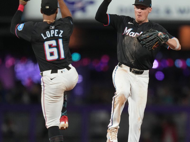 Sep 20, 2024; Miami, Florida, USA;  Miami Marlins second baseman Otto Lopez (61) and right fielder Griffin Conine (56) celebrate a victory over against the Atlanta Braves at loanDepot Park. Mandatory Credit: Jim Rassol-Imagn Images