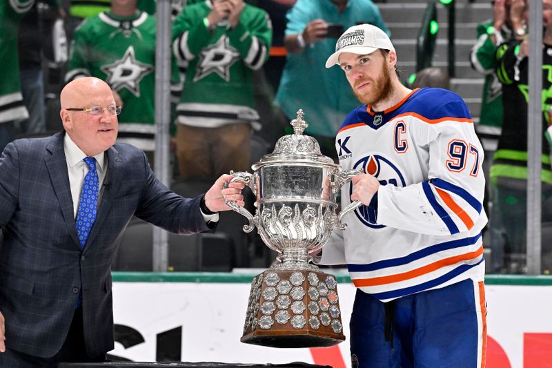 May 29, 2025; Dallas, Texas, USA; NHL deputy commissioner Bill Daly and Edmonton Oilers center Connor McDavid (97) pose with the trophy after winning the Western Conference Final of the 2025 Stanley Cup Playoffs at American Airlines Center. Mandatory Credit: Jerome Miron-Imagn Images