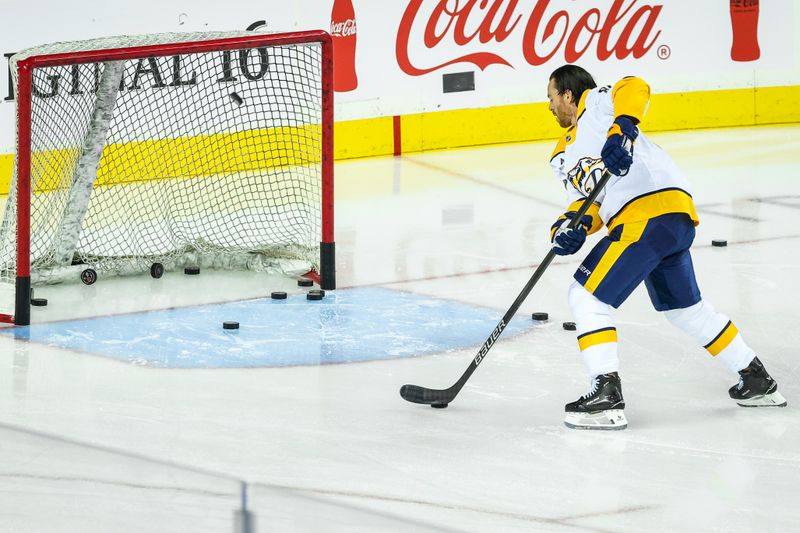 Nov 15, 2024; Calgary, Alberta, CAN; Nashville Predators center Jonathan Marchessault (81) shoots the pucks during the warmup period against the Calgary Flames at Scotiabank Saddledome. Mandatory Credit: Sergei Belski-Imagn Images