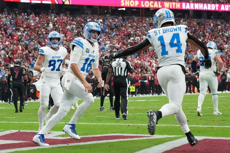 Detroit Lions wide receiver Amon-Ra St. Brown (14) celebrates his five-yard touchdown reception with quarterback Jared Goff (16) during the first half of an NFL football game against the Arizona Cardinals Sunday, Sept. 22, 2024, in Glendale, Ariz. (AP Photo/Rick Scuteri)