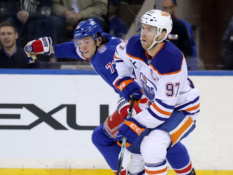 Oct 14, 2025; New York, New York, USA; Edmonton Oilers center Connor McDavid (97) skates with the puck against New York Rangers center Matt Rempe (73) during the third period at Madison Square Garden. Mandatory Credit: Brad Penner-Imagn Images