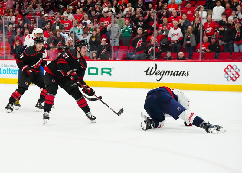 Nov 3, 2024; Raleigh, North Carolina, USA;  Carolina Hurricanes right wing Andrei Svechnikov (37) scores an empty net goal past Washington Capitals defenseman John Carlson (74) during the third period at Lenovo Center. Mandatory Credit: James Guillory-Imagn Images