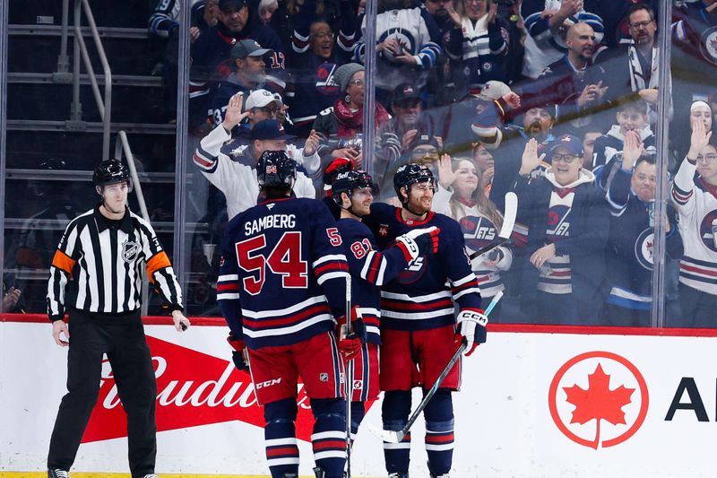 Jan 14, 2025; Winnipeg, Manitoba, CAN;  Winnipeg Jets forward Kyle Connor (81) celebrates with teammates after scoring a goal against the Vancouver Canucks during the first period at Canada Life Centre. Mandatory Credit: Terrence Lee-Imagn Images