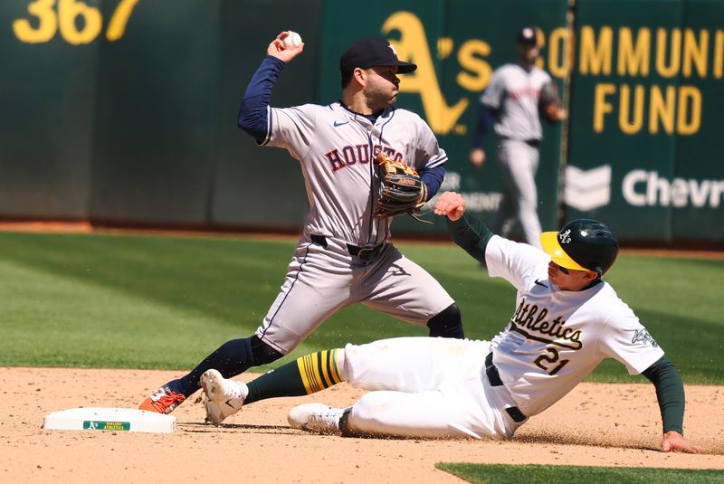 May 25, 2024; Oakland, California, USA; Houston Astros second baseman Jose Altuve (27) turns a double play against Oakland Athletics first baseman Tyler Soderstrom (21) during the eighth inning at Oakland-Alameda County Coliseum. Mandatory Credit: Kelley L Cox-USA TODAY Sports