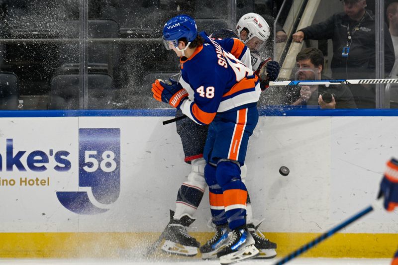 Nov 2, 2025; Elmont, New York, USA;  New York Islanders defenseman Matthew Schaefer (48) checks Columbus Blue Jackets left wing Miles Wood (11) into the boards during the second period at UBS Arena. Mandatory Credit: Dennis Schneidler-Imagn Images