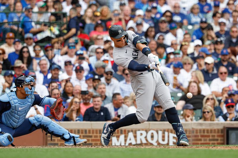 Sep 6, 2024; Chicago, Illinois, USA; New York Yankees outfielder Aaron Judge (99) hits an RBI-double against the Chicago Cubs during the third inning at Wrigley Field. Mandatory Credit: Kamil Krzaczynski-Imagn Images