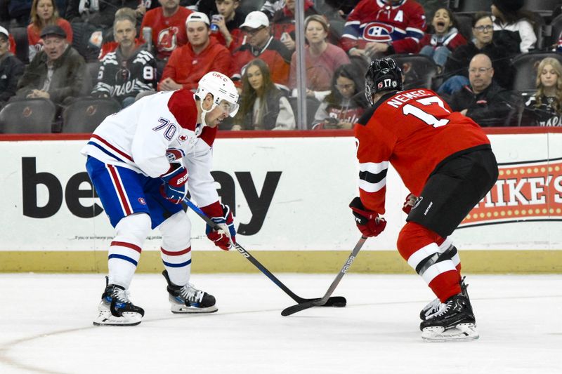 Feb 24, 2024; Newark, New Jersey, USA; Montreal Canadiens left wing Tanner Pearson (70) passes the puck while being defended by New Jersey Devils defenseman Simon Nemec (17) during the first period at Prudential Center. Mandatory Credit: John Jones-USA TODAY Sports