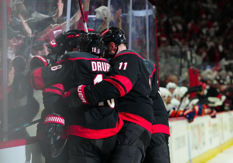 Apr 22, 2024; Raleigh, North Carolina, USA; Carolina Hurricanes left wing Jordan Martinook (48) is congratulated by center Jack Drury (18) and center Jordan Staal (11) after his goal against the New York Islanders during the third period in game two of the first round of the 2024 Stanley Cup Playoffs at PNC Arena. Mandatory Credit: James Guillory-USA TODAY Sports