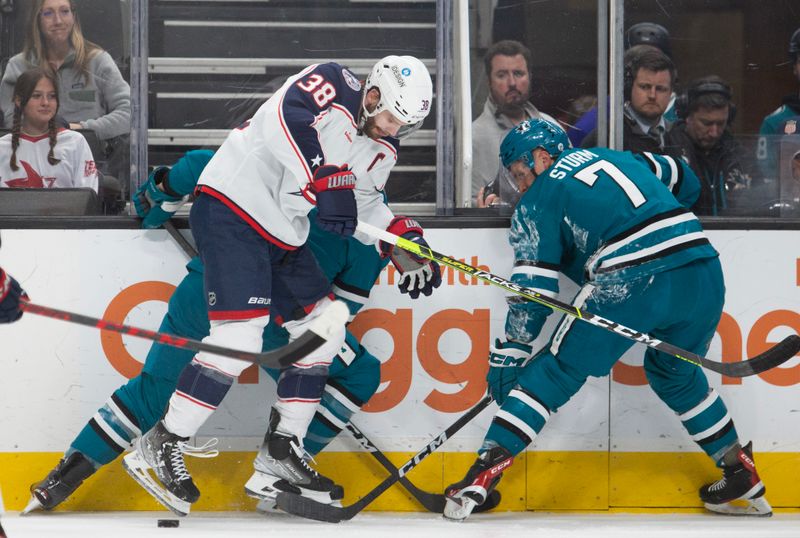 Mar 14, 2023; San Jose, California, USA; Columbus Blue Jackets center Boone Jenner (38) battles for the puck with San Jose Sharks defenseman Matt Benning (hidden) and center Nico Sturm (7) during the first period at SAP Center at San Jose. Mandatory Credit: D. Ross Cameron-USA TODAY Sports