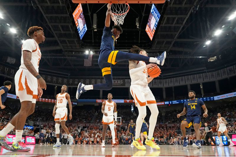 Feb 11, 2023; Austin, Texas, USA; West Virginia Mountaineers forward Mohamed Wague (11) dunks over Texas Longhorns forward Christian Bishop (32) during the first half at Moody Center. Mandatory Credit: Scott Wachter-USA TODAY Sports