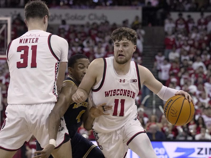 Dec 3, 2024; Madison, Wisconsin, USA; Wisconsin guard Max Klesmit (11) takes advantage of a pick by =tph31n- on Michigan guard Nimari Burnett (4) during the second half of their game Tuesday, December 3, 2024 at the Kohl Center in Madison, Wisconsin. Michigan beat Wisconsin 67-64.  Mandatory Credit: Mark Hoffman/USA TODAY Network via Imagn Images 