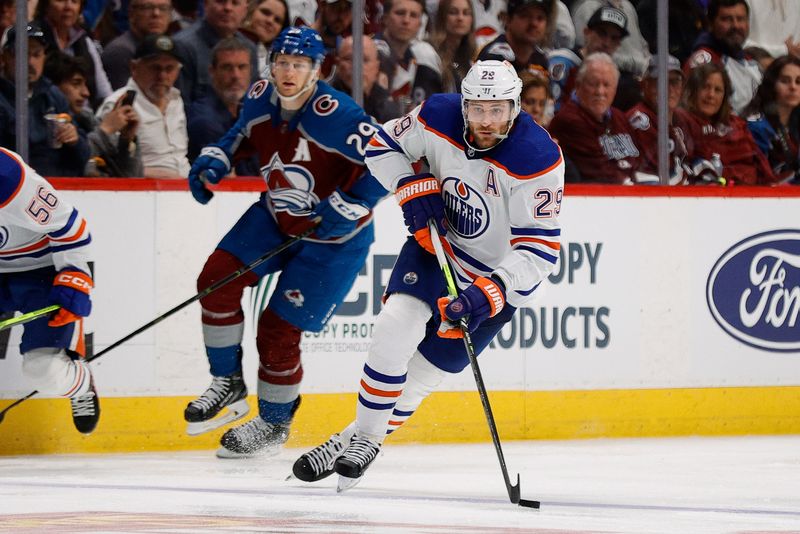 Apr 11, 2023; Denver, Colorado, USA; Edmonton Oilers center Leon Draisaitl (29) controls the puck ahead of Colorado Avalanche center Nathan MacKinnon (29) in the third period at Ball Arena. Mandatory Credit: Isaiah J. Downing-USA TODAY Sports