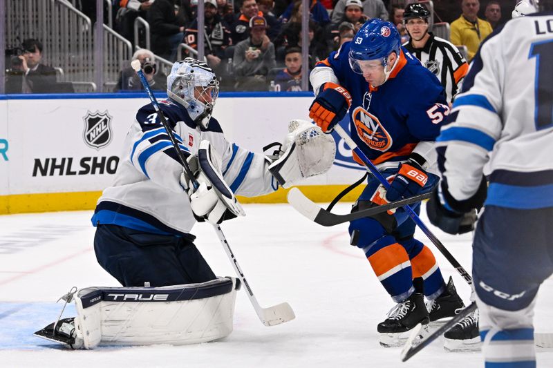 Mar 23, 2024; Elmont, New York, USA;  New York Islanders center Casey Cizikas (53) attempts to to score on a rebound in front of Winnipeg Jets goaltender Laurent Brossoit (39) during the second period at UBS Arena. Mandatory Credit: Dennis Schneidler-USA TODAY Sports