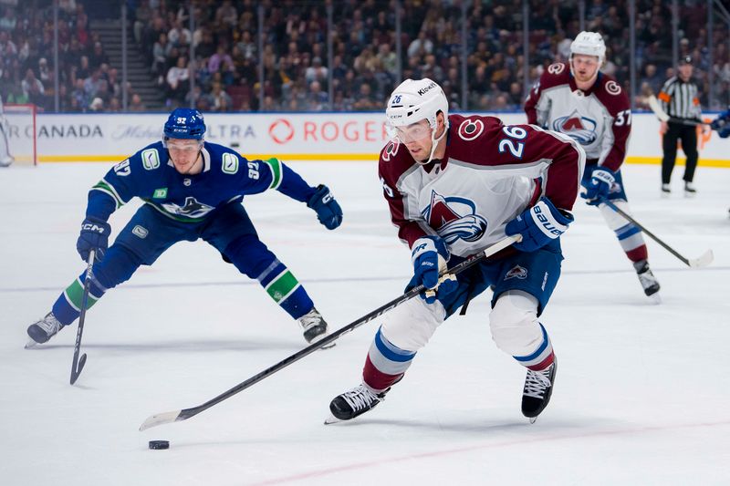 Mar 13, 2024; Vancouver, British Columbia, CAN; Vancouver Canucks forward Vasily Podkolzin (92) watches as Colorado Avalanche defenseman Sean Walker (26) handles the puck in the first period at Rogers Arena. Mandatory Credit: Bob Frid-USA TODAY Sports