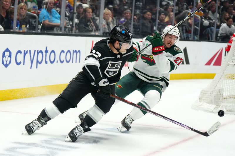 Apr 15, 2024; Los Angeles, California, USA; LA Kings left wing Kevin Fiala (22) and Minnesota Wild center Jacob Lucchini (27) battle for the puck in the third period at Crypto.com Arena. Mandatory Credit: Kirby Lee-USA TODAY Sports