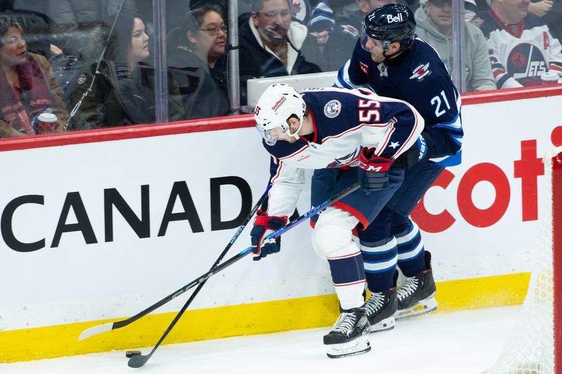 Jan 9, 2024; Winnipeg, Manitoba, CAN; Columbus Blue Jackets defenseman David Jiricek (55) skates with the puck as Winnipeg Jets forward Dominic Toninato (21) defends during the third period at Canada Life Centre. Mandatory Credit: Terrence Lee-USA TODAY Sports