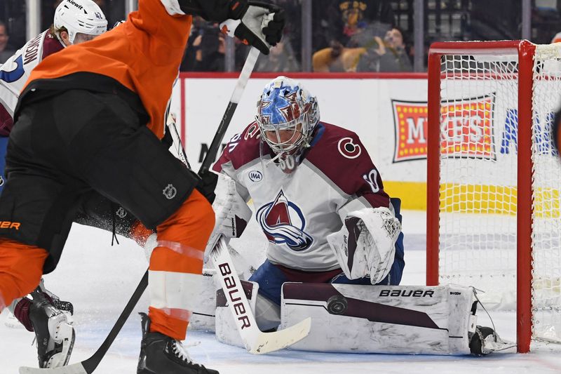 Nov 18, 2024; Philadelphia, Pennsylvania, USA; Colorado Avalanche goaltender Justus Annunen (60) makes a save against Philadelphia Flyers defenseman Travis Sanheim (6) during the third period at Wells Fargo Center. Mandatory Credit: Eric Hartline-Imagn Images