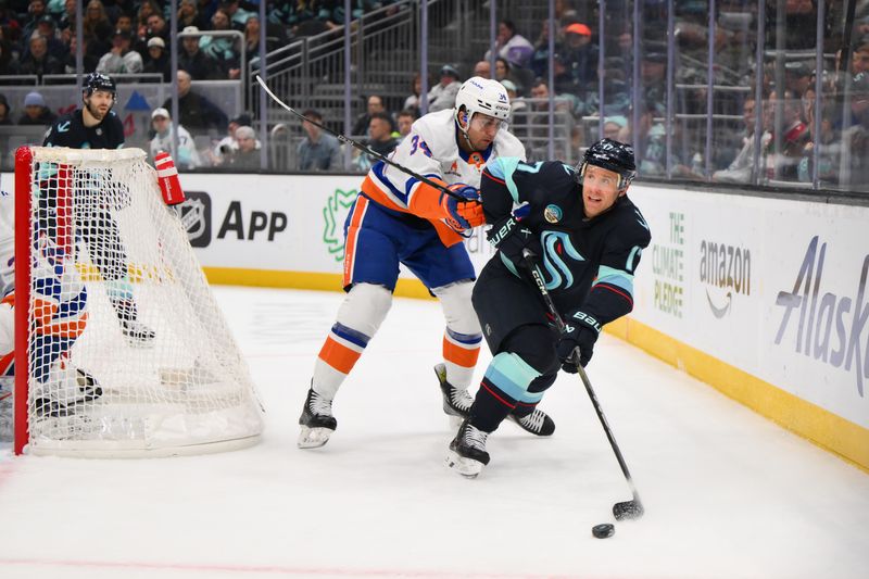 Nov 16, 2024; Seattle, Washington, USA; Seattle Kraken center Jaden Schwartz (17) passes the puck while defended by New York Islanders defenseman Grant Hutton (34) during the third period at Climate Pledge Arena. Mandatory Credit: Steven Bisig-Imagn Images