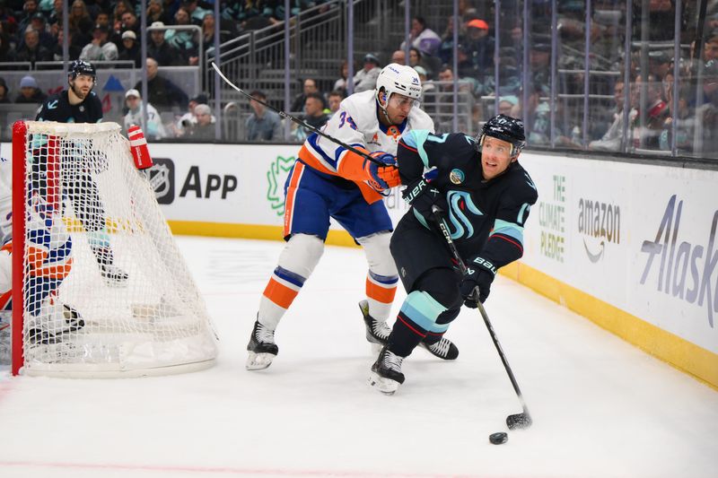 Nov 16, 2024; Seattle, Washington, USA; Seattle Kraken center Jaden Schwartz (17) passes the puck while defended by New York Islanders defenseman Grant Hutton (34) during the third period at Climate Pledge Arena. Mandatory Credit: Steven Bisig-Imagn Images