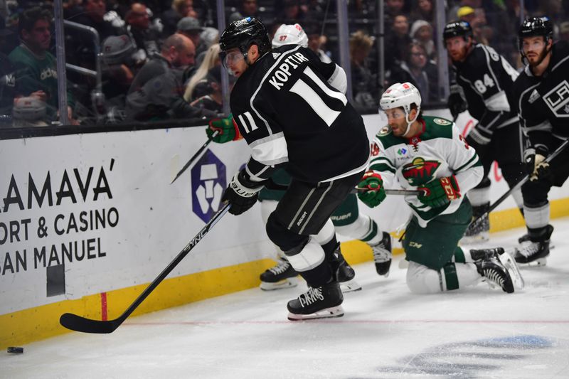 Mar 20, 2024; Los Angeles, California, USA; Los Angeles Kings center Anze Kopitar (11) moves the puck against the Minnesota Wild during the first period at Crypto.com Arena. Mandatory Credit: Gary A. Vasquez-USA TODAY Sports